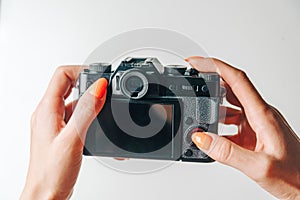 WomanÃ¢â¬â¢s hands using photo camera with empty screen.